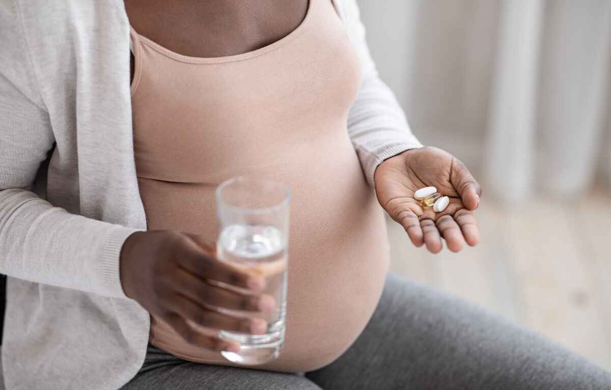 Pregnant woman takes prenatal vitamins
